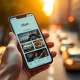 Hand holding smartphone showing Uber app with ride, hotel, and food options in a city setting