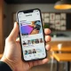 Person holding smartphone showing Venmo's redesigned app feed with social features and larger images