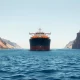 Oil tanker sailing through the Strait of Hormuz under a clear sky