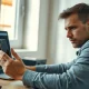 Person reviewing chatbot financial advice on a laptop and phone in a home office