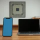 iPhone 17 Pro and MacBook Pro on a desk with a blurred microchip pattern in the background