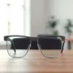 A smart glasses prototype on a desk in a modern office, representing Apple's upcoming AI-powered wearable and the hardware team now led by Paul Meade.
