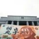 Bank of Japan headquarters in Tokyo with Japanese yen banknote in foreground