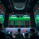Stock exchange trading floor in Shanghai with green stock charts on digital screens