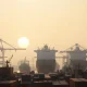 Container ship at a Chinese port at dawn, representing mixed economic signals.