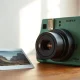 Fujifilm Instax Wide 400 instant camera in green with a wide-format photo on a wooden table