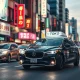 A taxi or autonomous vehicle driving through a Tokyo city street at night with neon signs