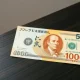 Japanese 10,000 yen note next to a US dollar bill on a desk