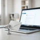 A laptop with a Gmail inbox and a small AI agent device on a modern desk.