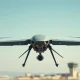 A military-grade drone in flight during a test, representing Stark's defense technology.