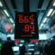 Stock market ticker board showing red and green numbers during volatile trading