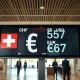 Currency exchange board showing Swiss franc, US dollar, and euro rates in a Zurich bank.