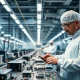 Inside a Tata Electronics semiconductor manufacturing facility in India with workers in cleanroom suits