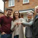 Young couple with grandparents outside a terraced house, representing family help for a first home purchase