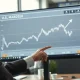 Financial analyst reviewing a chart showing record high equity allocations and sustained Dollar exposure.