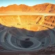 Aerial view of a large copper mine in Chile with terraced levels and mining trucks.