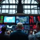 NYSE trading floor with Dow Jones screens and Middle East map showing muted market reaction to ceasefire news