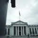 Exterior of the Federal Reserve building in Washington, D.C., on a cloudy day.