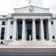 Exterior of the Federal Reserve building in Washington, D.C., under overcast skies.