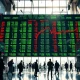 Stock market display board showing green and red numbers in a financial district