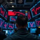 Wall Street trading floor with red declining AI stock charts on monitors