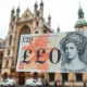 Close-up of a British £20 polymer banknote with Westminster Abbey in the background, symbolizing the Pound Sterling rally ahead of the coronation.
