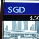 Singapore dollar exchange rate board against US dollar in a financial district setting