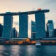 Singapore skyline at dusk with Marina Bay Sands and financial district buildings reflected in calm water