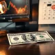 US dollar banknote on desk with DXY chart on monitor and calendar marking Fed minutes date