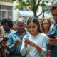 People looking at smartphones with skeptical expressions, illustrating public unease about AI.