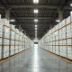 Warehouse filled with stacked Apple product boxes, representing inventory stockpile amid supply constraints.