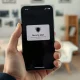 Person holding an iPhone displaying a security alert notification about a spyware attack