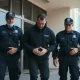 Australian Federal Police officers escort a handcuffed suspect outside a Perth police station