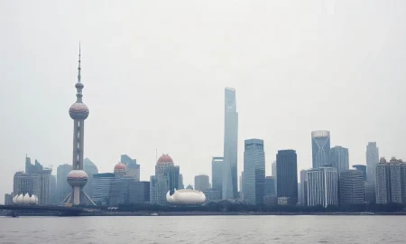 Shanghai skyline with Oriental Pearl Tower under overcast sky, reflecting subdued economic conditions