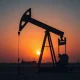 Oil pumpjack in a desert field at sunset, representing crude oil supply concerns.