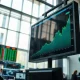 Stock market chart on a trading floor display showing an upward trend, reflecting equity market resilience.
