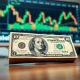 US dollar banknote and financial charts on a monitor in a trading office