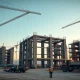 Construction site of a large hyperscale data center with cranes and workers at dusk.