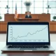 Courtroom scene with laptop showing flight cancellation graph, symbolizing FlightAware's lawsuit against Kalshi