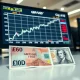 Close-up of GBP/USD trading chart with British Pound and US Dollar banknotes on a desk