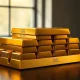 Gold bullion bars stacked on a dark surface, representing rising gold prices.