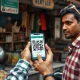 Shopper scanning a UPI QR code at a small merchant stall in India