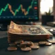 Indian Rupee banknotes and coins on a desk with a financial chart in the background