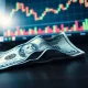 Japanese yen banknote and US dollar on desk with trading monitor showing USD/JPY chart decline