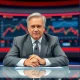 Larry Kudlow speaking on a news set, with a stock chart in the background.