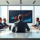 Business executives in a modern boardroom viewing data analytics on a large screen.