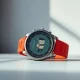 Pebble Time 2 smartwatch with red band and pixelated watch face on a studio surface