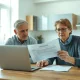 Couple reviewing pension documents at home, concerned about taper tax charges