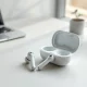 Plaud One wireless earbuds with their charging case on a desk