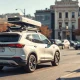 Autonomous test vehicle with rooftop sensors parked on a city street